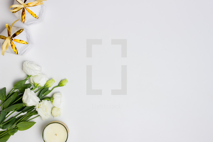 white roses and candles on a white background 