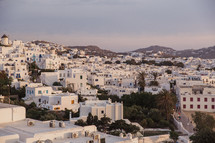 A city of white buildings on rolling hills.