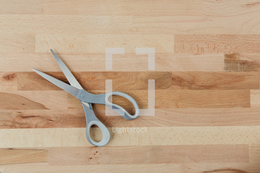 scissors on a wood cutting board