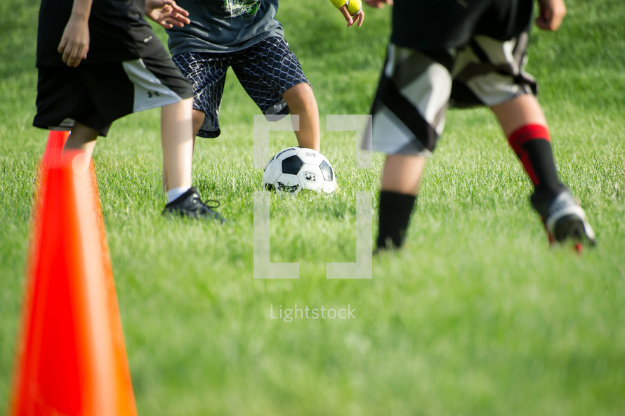 legs of young boys playing soccer 