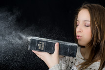 A woman blowing off dust from a Bible 