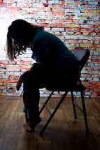 depressed woman sitting in a folding chair 