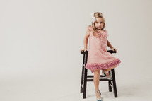 little girl getting onto a stool 