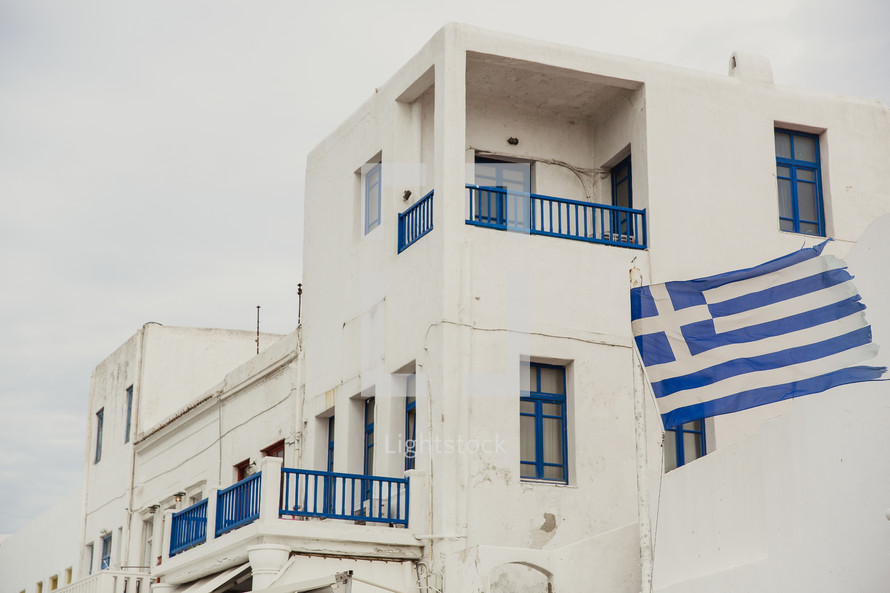 balconies on a white building and Greek flag 