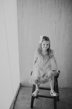 girl child sitting on a stool 