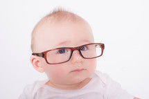 Infant wearing a pair of an adults glasses