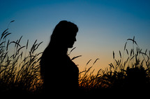 silhouette of a woman in a field 
