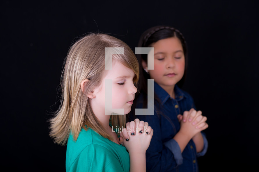 young girls with praying hands 