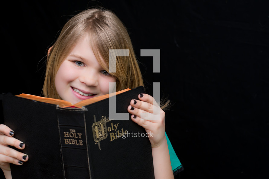 A little girl reading a Bible 