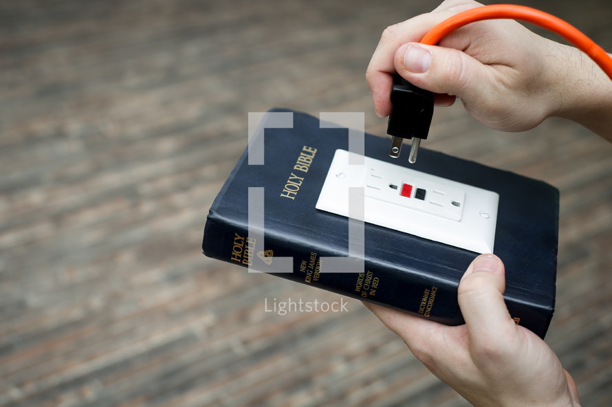 power of scripture - Bible with an outlet and power cord about to be plugged in