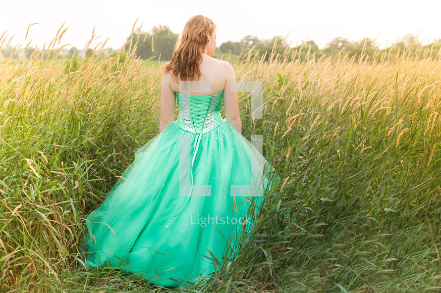 girl in a green prom dress in a field