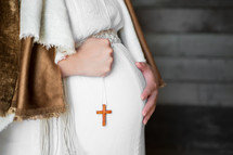 pregnant Mother Mary holding a cross