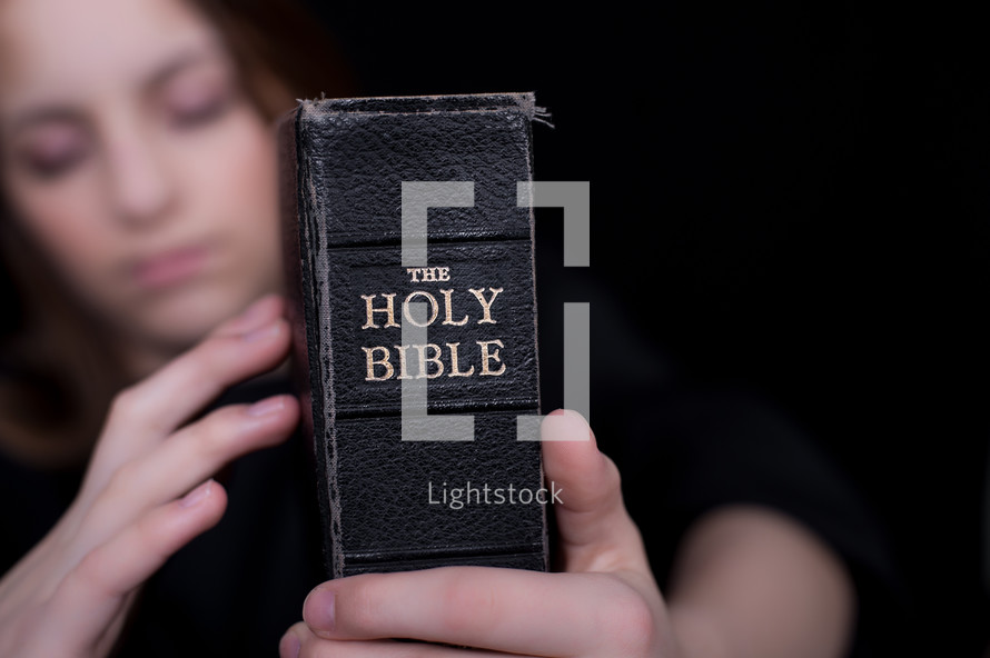Girl holding a Bible.