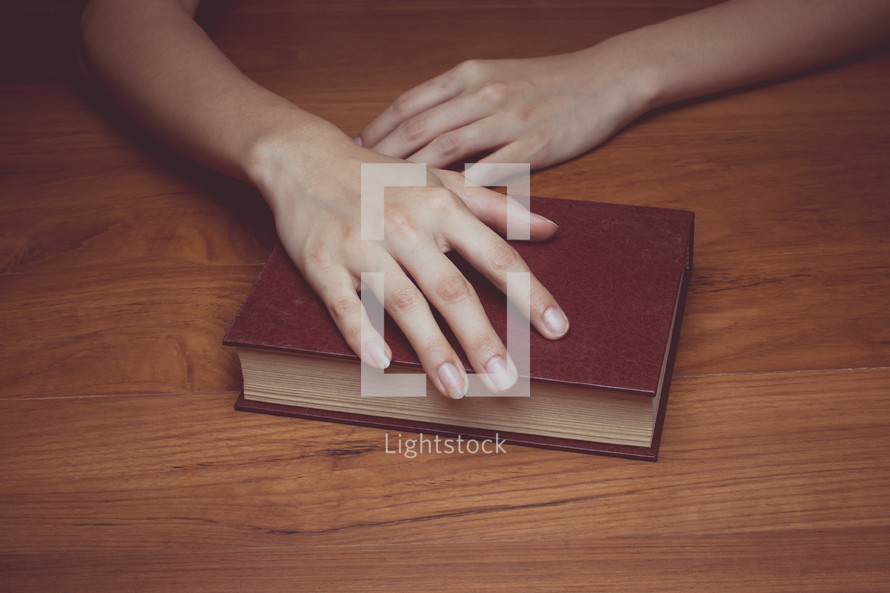 A hand resting on a Bible 