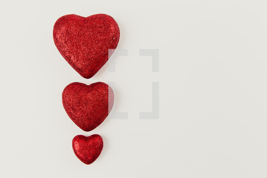 three red hearts on a white background 