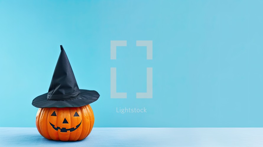 Halloween pumpkin with witch hat on blue background. Space for text