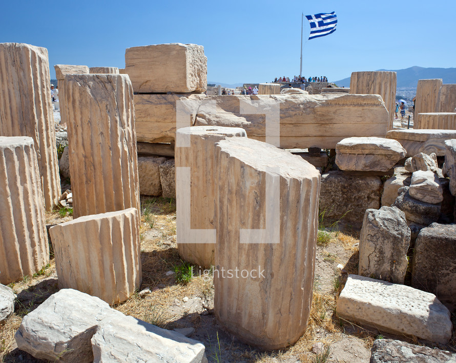 Ancient ruins in Athens with Greece flag on background