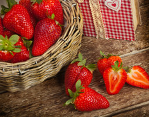 Beautiful strawberries with cookbook on wooden table