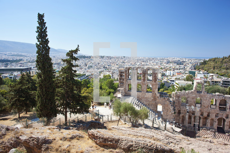 The Odeon of Herodes Atticus with the city of athens is in the background.