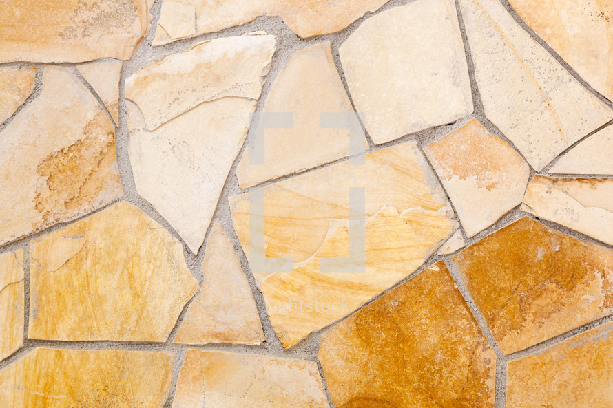 Wall lined with light yellow porphyry stones