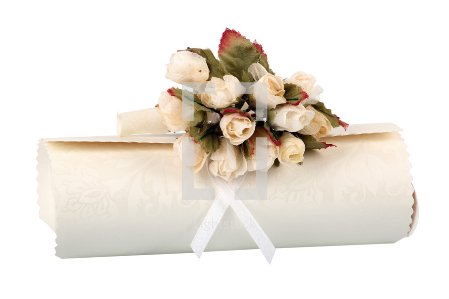 Rolled parchment with bunch of fake roses on white