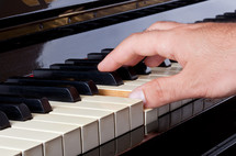 hands playing a piano 