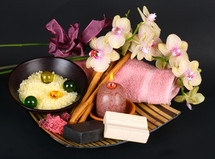 Spa accessories with orchid flowers on black background