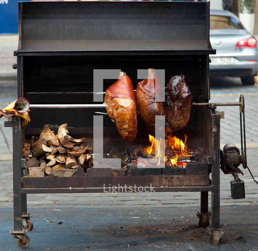 Pork cooking on a wood stove in the street of Prague.