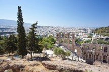 The Odeon of Herodes Atticus with the city of athens is in the background.
