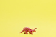dinosaur figurine on yellow background 
