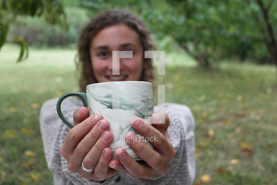 young woman holding a mug 