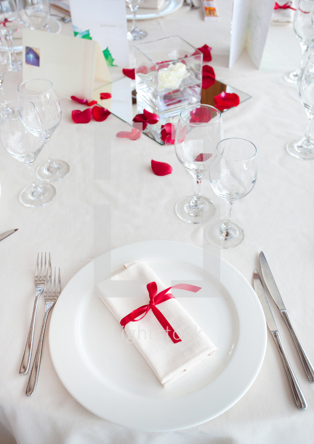 Table set for a Wedding reception with red decorations.