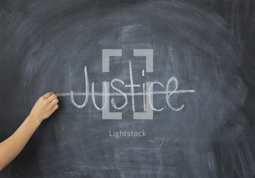 crossing through the word Justice on a chalkboard 