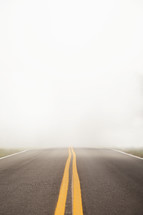 center lines on a road with fog 