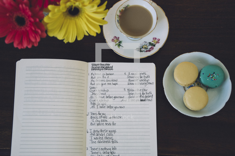gerber daisies, notes in a notebooks, and coffee and macarons 