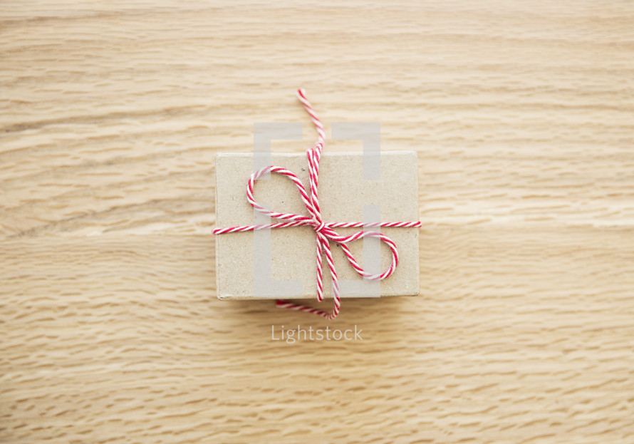 red and white string around a brown paper gift box 