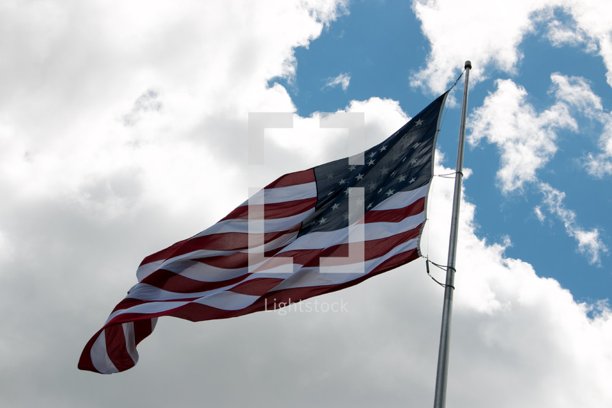 American flag on a flag pole blowing in the wind 