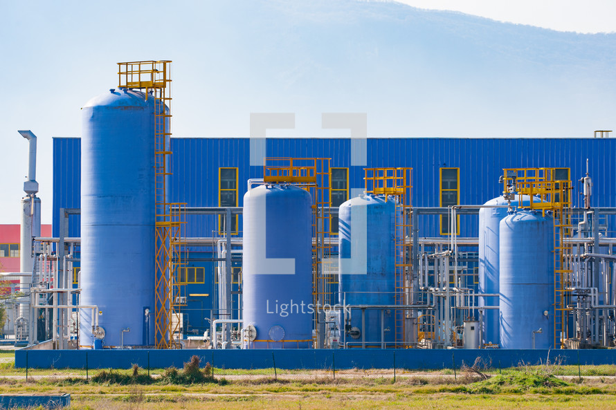 Industrial silos of a modern factory, everything is painted blue.