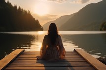 Close up of a caucasian woman enjoying a tranquil sunset by a calm mountain lake