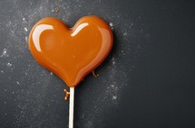 Close up of a caramel heart-shaped lollipop