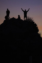 silhouette of people standing on a hill 