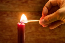 lighting a candle with a match 
