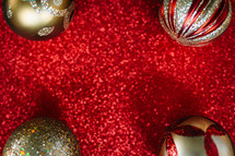 Christmas ornaments on a red glittery background 