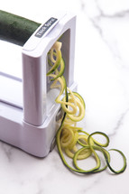 zucchini Squash Being Cut into Pasta Like Twirls for a Healthy Alternative to Pasta