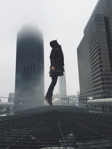man leaping in a foggy city 