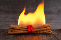Flames with Sticks of Cinnamon on a Wooden Table