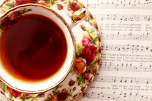 tea in a tea cup and sheet music 