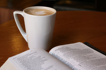 mug and open Bible on a table 