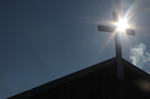 Mongolian church cross with winter sun radiating behind