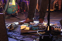 man's feet on guitar pedals 